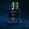 Blue perfume bottle labeled 'esse Spirit Blue' on a blue textured background