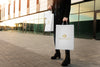 Customer holding Essence De Royal shopping bag representing a luxury lifestyle