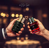 Two hands holding 'esse scent' perfume bottles labeled 'Black' and 'Red' against a blurred background.